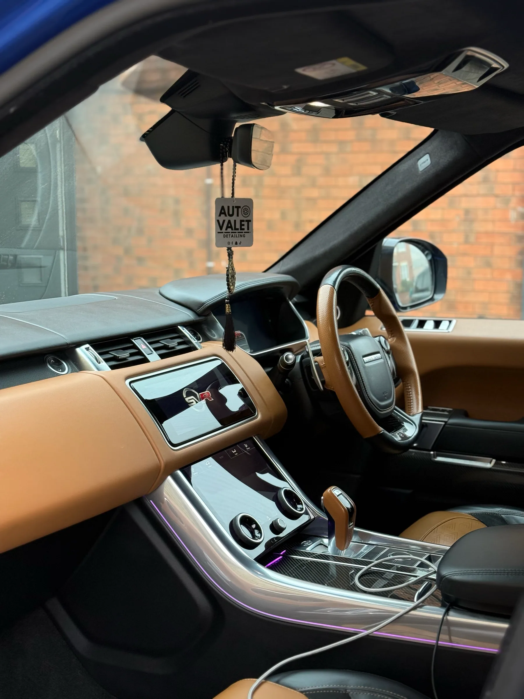 Luxury vehicle cabin with clean leather and centre console after detailing