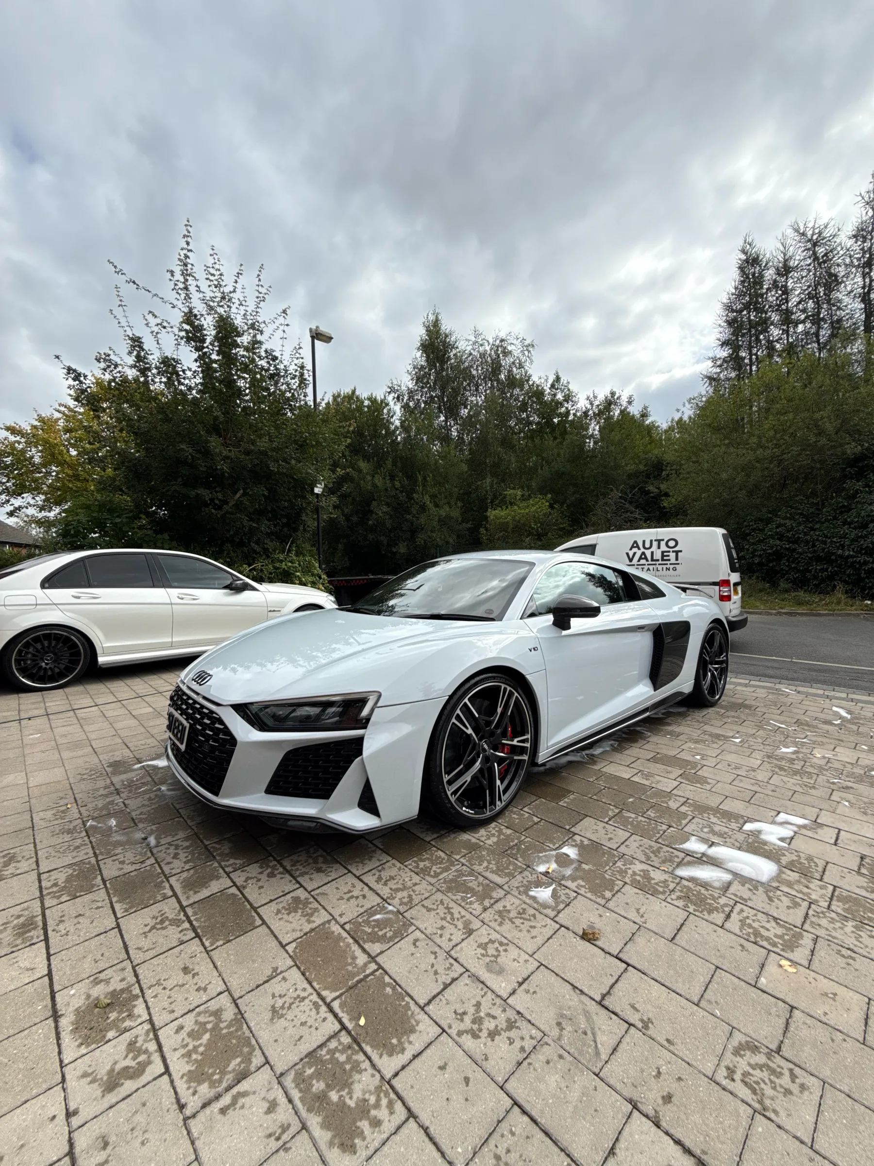 White Audi exterior after detailing beside the AUTO VALET van